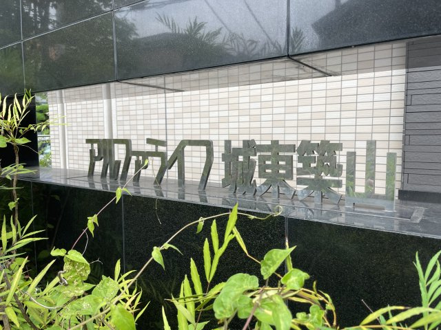 アルファライフ城東築山のその他|緑豊かな植栽に囲まれた館銘板が、住まいの顔として落ち着いた印象を演出しています。