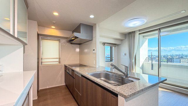 レジデンシャル泉中央のキッチン|石目調天板の対面式システムキッチン。IHクッキングヒーター・食器洗乾燥機付です。