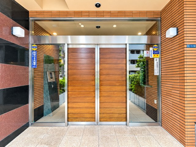 ラ・コピエ大井町のエントランス|重厚感のあるレンガタイルと木目調の扉が印象的なエントランス。上質で落ち着いた雰囲気が住まいの品格を演出します。