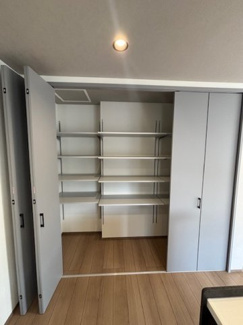 【居間・リビング】 | 中区江波西1丁目（舟入南電停）全1区画【外構込み】 | キッチン横に配した大容量の可動棚収納。扉付きのため、生活感を隠しながらストック品や日用品を効率よく保管できます。棚板の高さが調整可能で、サイズの異なる荷物も無駄なく収まります。
