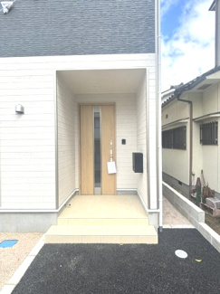 【玄関】 | 東広島市黒瀬町国近字松崎山　全1棟 | 屋根のあるポーチ空間で雨の日の出入りも安心。木目調の上質な玄関ドアが住まいの顔として温かみのある空間を演出。セキュリティ面にも配慮された仕様です。