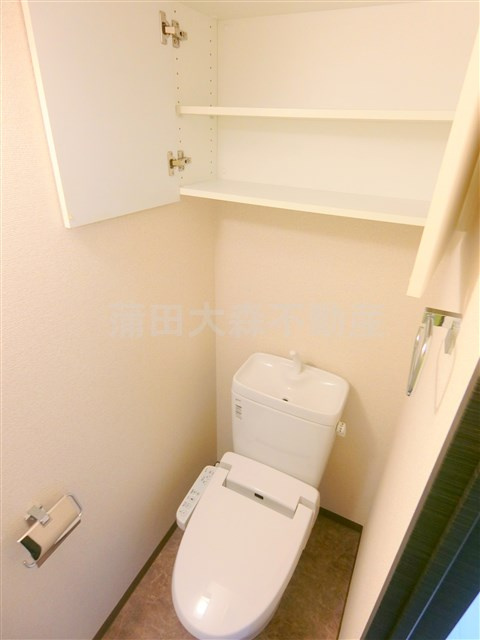 スカイコート蒲田壱番館のトイレ|吊戸棚と温水洗浄便座付きのトイレ