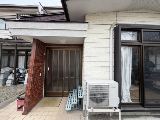 生活施設が揃う中古戸建～宮城県石巻市清水町二丁目～の玄関|赤レンガ風の壁面がアクセント。屋根付きアプローチです。