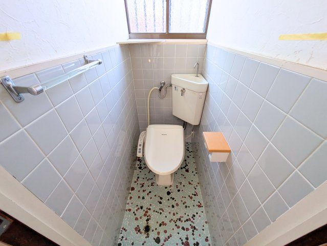 太山寺町戸建てのトイレ|清潔感のある温水洗浄便座付きトイレです。手洗い器や明かり取りの窓を備え、快適な空間に整っています。