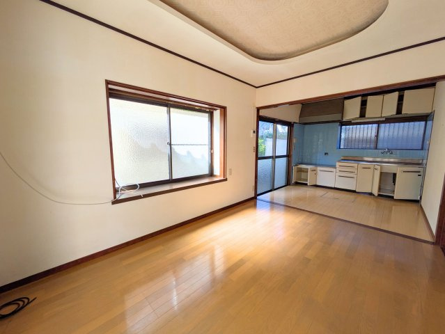 太山寺町戸建ての居間・リビング|出窓から優しい光が差し込む居間です。奥のキッチンへと見通しが良く、家事をしながら会話が弾みます。