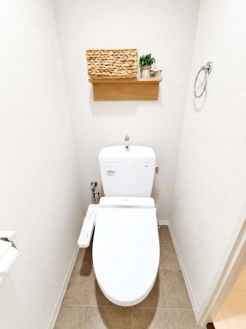 伊丹春日丘アーバンコンフォートA棟のトイレ|清潔感のあるトイレです。グレーのタイル調の床がアクセントとなり、落ち着いたおしゃれな空間です。