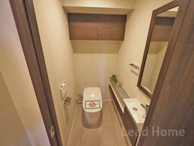【トイレ】 | グランスイート三軒茶屋スカイテラス | 専用の手洗いカウンターや鏡が備わったトイレです。上部の扉付き吊戸棚でストック類も隠して収納可能！