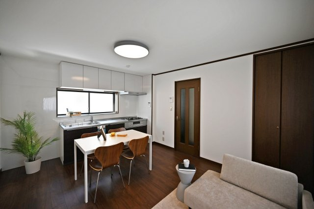 尼崎市武庫川町4丁目中古戸建│4DK+駐車1台可の居間・リビング|約10帖のDKは、ダイニングセットとソファを置いても空間を分けて使いやすい広さ。壁面には収納も備わり、生活用品をまとめてしまえます。落ち着いた木目と白を基調にした内装で、家具も合わせやすい空間です。