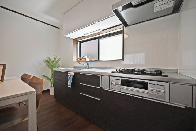 尼崎市武庫川町4丁目中古戸建│4DK+駐車1台可のキッチン|新調されたシステムキッチン。作業スペースを広く取れる壁付けタイプで、上下に収納もしっかり備わっています。正面には窓があり、手元に自然光が入るのもポイント。毎日のお料理がしやすいキッチンです。