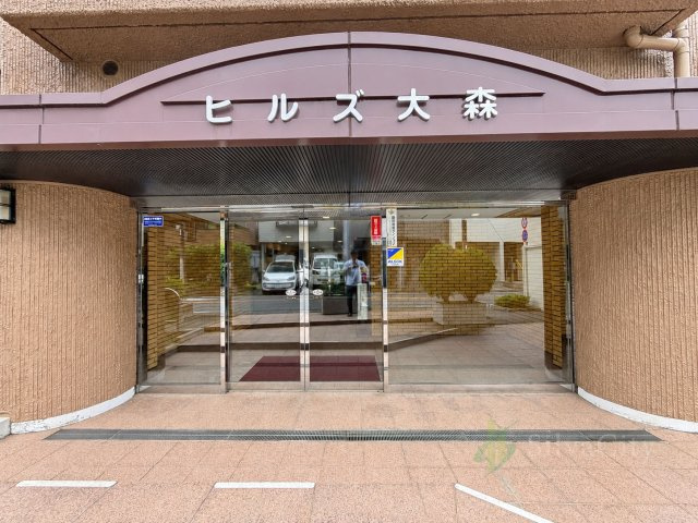 ヒルズ大森のエントランス|マンション名を掲げた存在感のあるエントランス。ガラス扉を採用した、明るく開放感のあるアプローチです。