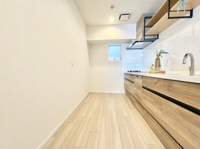 RICイーストコート3番街のキッチン|ご夫婦や親子で並んで立っても窮屈さを感じない、ゆとりある通路幅を確保。背面に大型冷蔵庫やカップボード（食器棚）を機能的に配置しやすく、食材の取り出しから調理、片付けまでの生活動線もスムーズです。