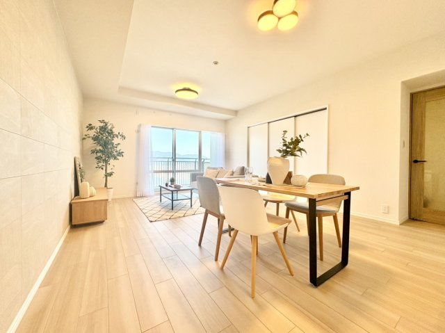 RICイーストコート3番街の居間・リビング|大きな窓から光が差し込む明るい約18.7帖の大空間。大型家具を置いても動線にゆとりがあるほか、隣接するお部屋の扉を開放すればさらに広い一体空間となり、家族の成長に合わせて柔軟に活用できます。