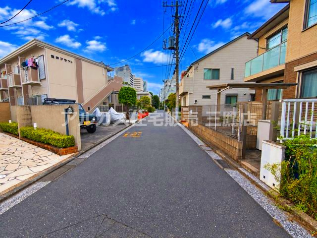武蔵野市御殿山2丁目 中央線 三鷹駅 売地の前面道路含む現地写真|物件前を通る前面道路の様子です。電柱や電線が通る落ち着いた住宅街の道路で、周辺には集合住宅や戸建てが並んでいます。