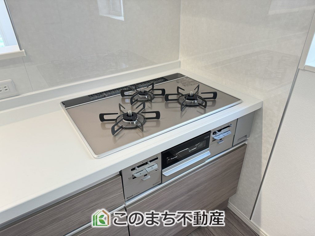 ワイウッドコートさくら市大中第1期のキッチン|三ツ口コンロ採用で、同時調理もスムーズ◎！お料理を並べられるカウンター付きで、配膳・片付けをサポート！リビングで過ごすご家族とコミュニケーションを楽しみながら作業可能です♪