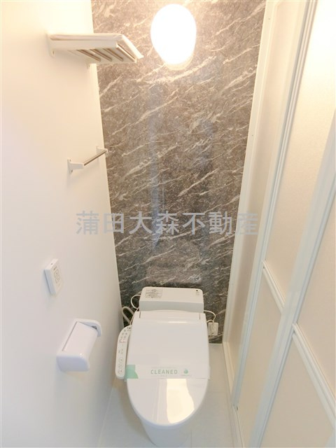 グローリア初穂池上のトイレ|棚と温水洗浄便座付きのトイレ