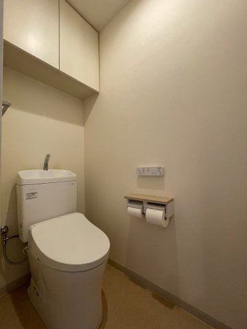 サーパス本町のトイレ|白を基調とした清潔感あふれるトイレ空間で、吊戸棚が付いているためすっきりと整理できます。