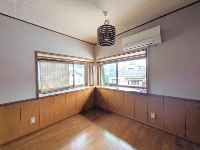 祝谷5丁目戸建ての洋室|コーナー出窓から優しい採光が届く洋室です。腰壁の木の温もりが居心地の良さを演出します。