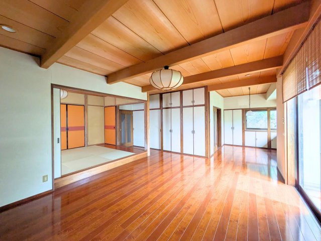 祝谷5丁目戸建ての居間・リビング|木の温もりに包まれる広々としたLDKです。小上がりの和室はくつろぎの空間として活躍します。