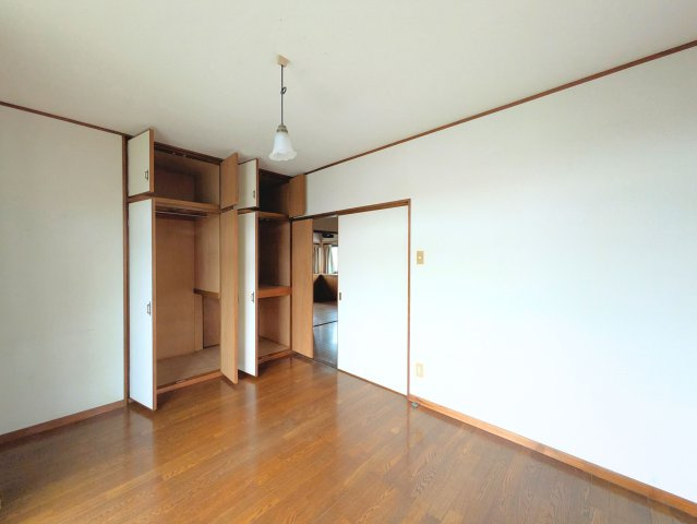 祝谷5丁目戸建ての洋室|木目が美しいフローリングの洋室です。大容量の壁面収納を備えており、衣類の整理に重宝します。