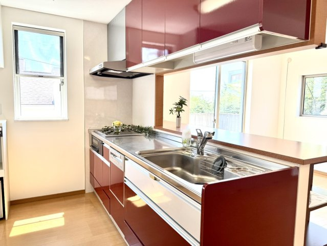 森北町7丁目戸建のキッチン|高級感が印象的なワインレッドの対面式システムキッチン。食器洗い乾燥機付きで食後の負担と水道料金を軽減。