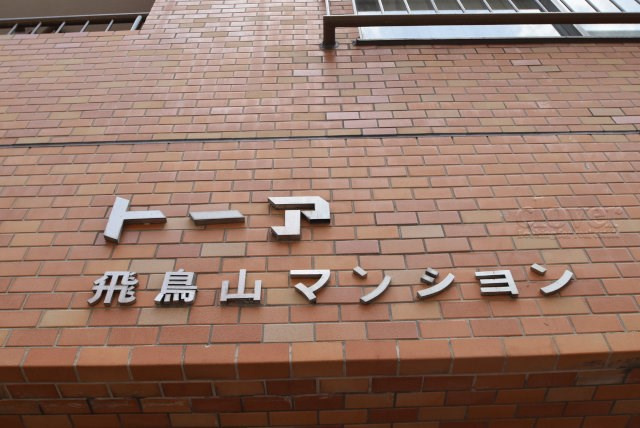 【現況写真】 | トーア飛鳥山マンション | エントランスに掲げられた、マンション名を示す館銘板。さほど激しく主張はしませんが、しっかりと掲示されています。～即日のご見学可能～　お問合せはお気軽にどうぞ。
