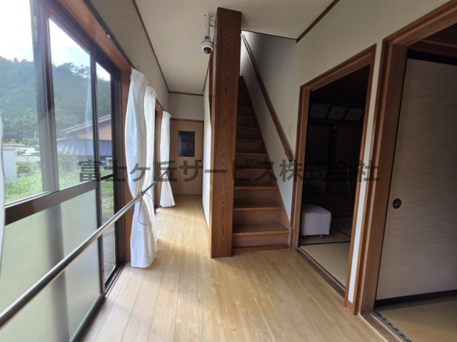 【内装】 | 森町三倉　中古住宅 | 大きな窓から光が差し込む明るい廊下です。窓沿いと階段には手すりが付いており、ご高齢の方も安心して移動できます。木目の美しい柱や階段が落ち着いた雰囲気を演出し、廊下から各和室へスムーズに行き来できます。