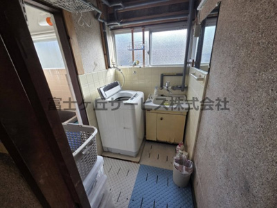 【洗面所】 | 森町三倉　中古住宅 | 洗面台と室内洗濯機置場を備えた洗面脱衣室です。浴室に隣接し、窓があるため換気や採光も確保できます。キッチンからも近く家事動線は良好。設備に経年劣化がみられるため、リフォームをおすすめします。