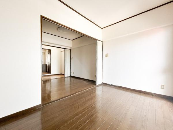 つかさアーバングリーン豊町の洋室|明るい光が差し込む洋室でナチュラルな雰囲気が魅力です。仕切りのドアを開ければ隣室との一体感も楽しめます。白とブラウンのコントラストがシンプルな印象を与えます。床は木目調で落ち着きを感じられます。