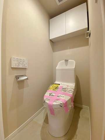 ワコーレ堀切菖蒲園Ⅱのトイレ|快適な温水洗浄機能付きのトイレへと新規交換済み。清潔感のあるスタイリッシュな空間に仕上がっており、トイレットペーパーや掃除用品をスマートに収納できる便利な棚も備えた落ち着けるトイレ空間です。