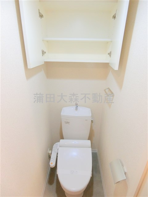 スカイコート蒲田弐番館のトイレ|吊り戸棚と温水洗浄便座付きのトイレ