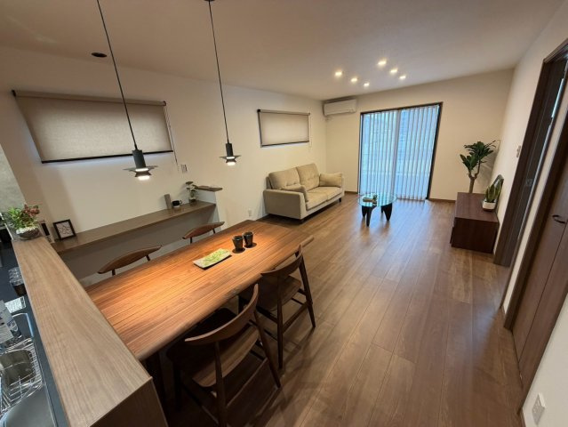 丸亀市津森町　【耐震等級3】ちょうどよく、心地いい。箱×片流れ屋根の家の居間・リビング|ダイニングテーブルとソファを置いても、余裕のある空間となっています。