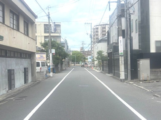 【前面道路含む現地写真】 | 南区東雲2丁目（更地）土地 | 物件の前面道路は幅員約8ｍの広々とした公道です。見通しが良く平坦な道路のため、お車の運転や出し入れ、歩行者の通行もスムーズ。周辺は落ち着いた街並みが広がっており、開放感のある立地です。