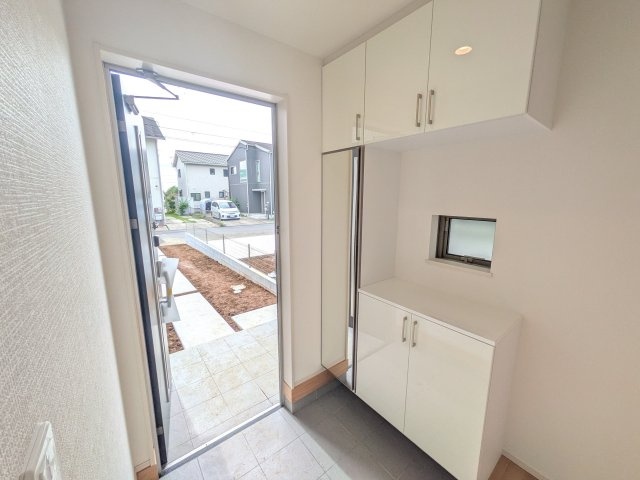 つくばみらい市富士見ヶ丘３丁目26番　新築戸建て　B号棟の玄関|家族全員の靴がスッキリ片付く大容量シューズボックス完備。
お客様を気持ちよく迎えられる、明るく清潔感あふれる玄関です。