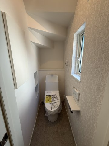 イチエHOUSE分譲　周南市下上のトイレ|№16
階段下のスペースを活用した1階トイレです。壁面にはカウンター付きの手すり・紙巻器を設置しています。