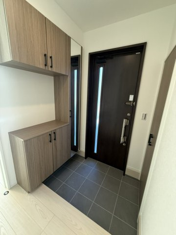 イチエHOUSE分譲　周南市下上の玄関|№16
木目調の玄関収納と全身姿見ミラーを備えた玄関スペース。スマートキー対応の玄関ドアを採用し、出入りもスムーズです。