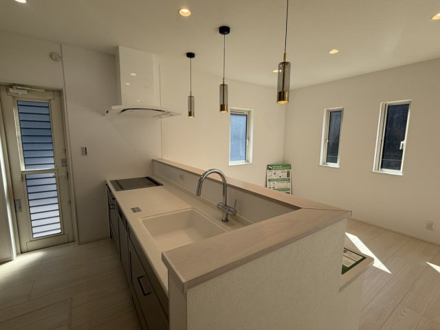 イチエHOUSE分譲　周南市下上のキッチン|№16
木目調カウンターとペンダントライトが映えるオープンキッチン。お料理中もリビング全体に視線が届き、家族との会話が楽しめます。