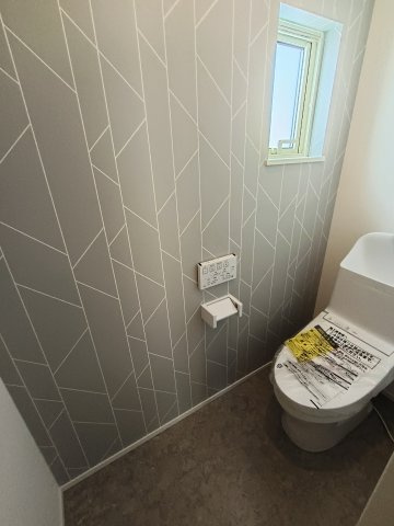セルリアンステージ 周陽二丁目のトイレ|アクセントクロスがおしゃれな清潔感あふれるトイレ空間。手洗い付き・手すりカウンターや小物収納を備え、機能性にも優れています。