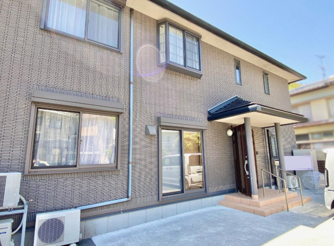 「二世帯におすすめ」高知市万々　中古一戸建ての外観|落ち着いた色合いの外壁が印象的な住まい。玄関には屋根があり、雨の日の出入りにも便利です。