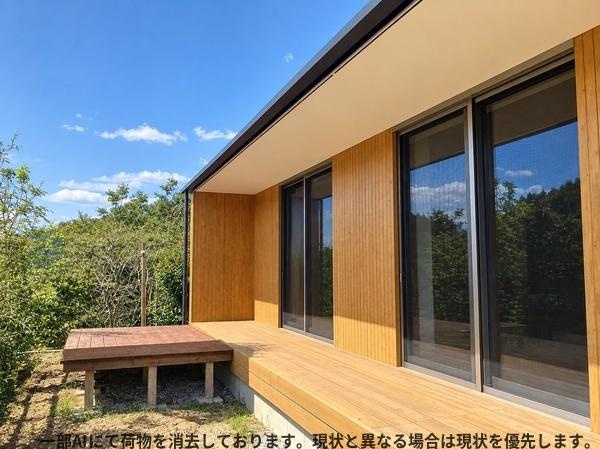 三重町　戸建てのその他|木目の外壁が印象的な住まいです。大きな窓からは自然光がたっぷり差し込みます。広々としたウッドデッキは多用途に活用できます。周囲の緑が景観を引き立てています。シンプルで洗練された外観が特徴です。