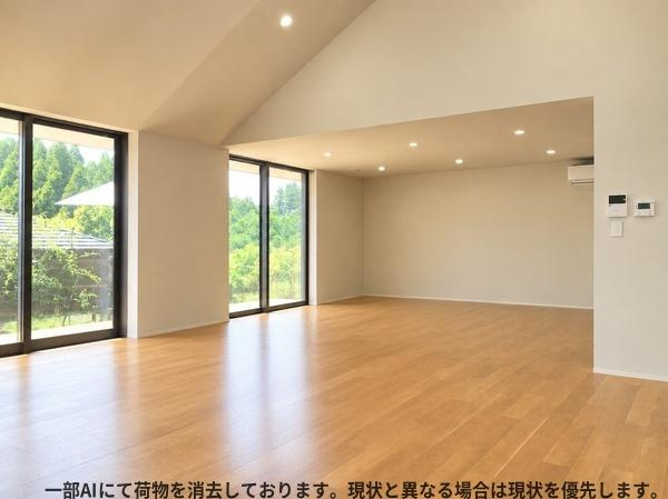 三重町　戸建ての居間・リビング|大きな窓から自然光がたっぷり入り明るさを感じられます。天井が高く開放感が魅力のリビングです。木目調のフローリングが空間を落ち着いた印象に仕上げます。