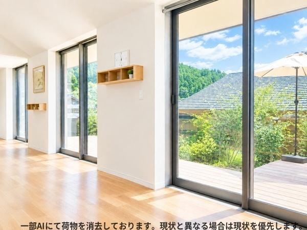 三重町　戸建ての居間・リビング|大きな窓からたっぷりと自然光が差し込むリビングです。明るく開放的な空間が広がります。床は清潔感のある木目調で室内をすっきりと見せます。窓の外には緑の景色を眺めることができます。