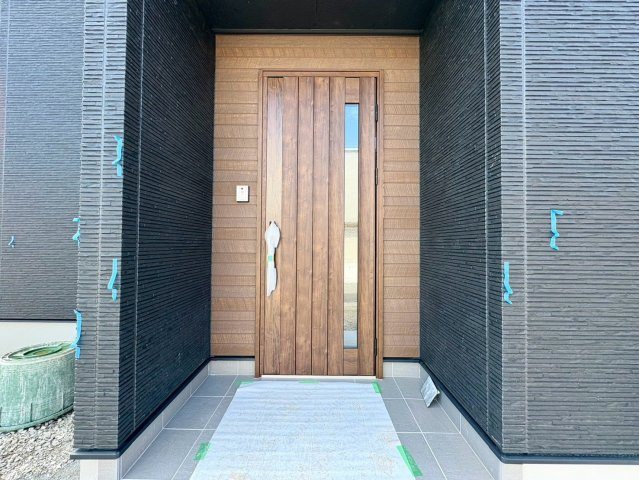 「開放感あふれる角地」土佐市蓮池2号地　新築一戸建ての玄関|木目調のあたたかみある玄関ドア。ベビーカーの出し入れもスムーズな広々としたエントランスです。