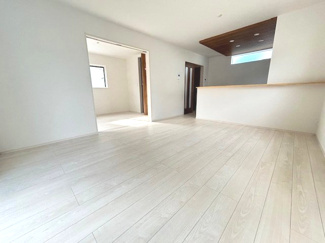 【居間・リビング】 | 佐伯区坪井1（楽々園駅）全3区画　NO1【外構工事込】 | 家具の配置がしやすい縦型のLDK。キッチン上部には木目調の下がり天井とダウンライトがあしらわれており、空間の程よいアクセントになっています。1階の各居室へスムーズに移動できる動線です。