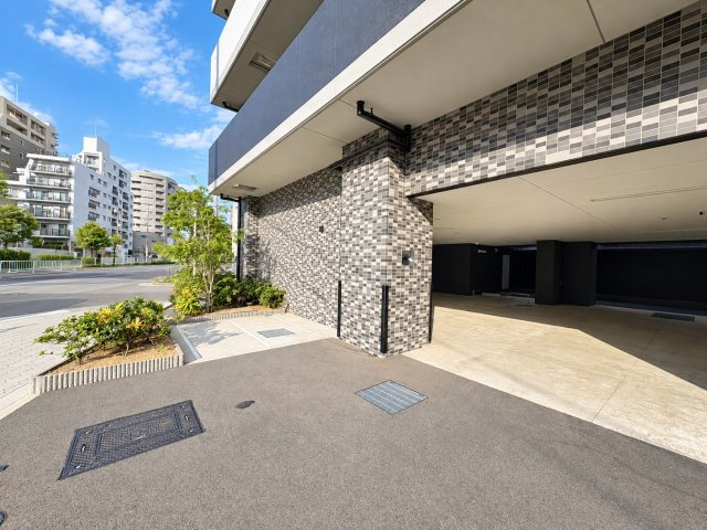 ワコーレ阿倍野播摩町ラフィリスの玄関|建物内に設けられた屋根付きの駐車スペースです。床面には区画線が引かれており、車両を停める位置が分かりやすくなっています。屋外からの出入りについても確認できる写真です。