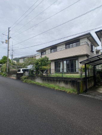 「南向きお庭付き」高知市春野町　中古一戸建ての前面道路含む現地写真|道路側から見た建物の様子。横に広がるバルコニーと、庭の植栽が印象的な住まいです。