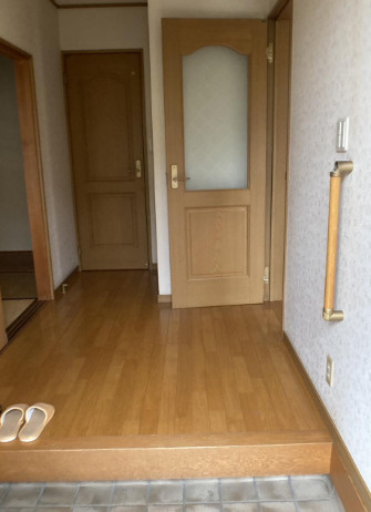 「南向きお庭付き」高知市春野町　中古一戸建ての玄関|木目の床が温かみを添える玄関ホール。上がり框付近には、立ち座りを支える手すりを備えています。
