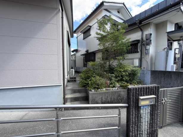 「平屋1LDK」高知市高須東町　中古一戸建ての外観|門扉から玄関へと続くアプローチ。植栽の緑が、住まいの入口に彩りを添えています。