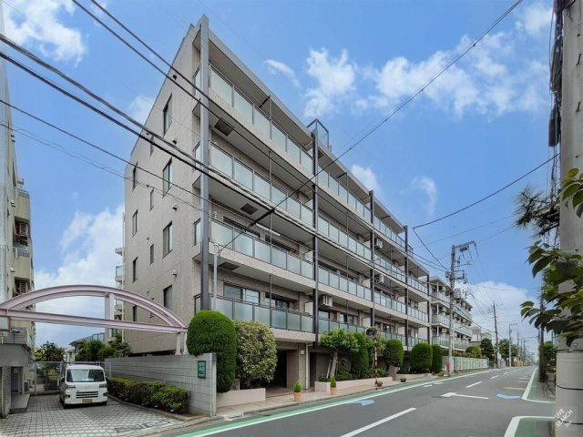 グランレーブ南馬込の外観|貴船坂の高台に佇む、地上6階建てのマンション。バルコニーが整然と並ぶ端正な外観と、建物周囲に配された植栽が印象的です。