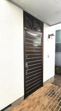 「小学校徒歩8分」香南市野市町東野　中古一戸建ての玄関|落ち着いた色合いの玄関ドア。タイル敷きの玄関ポーチが住まいの入口を彩ります。