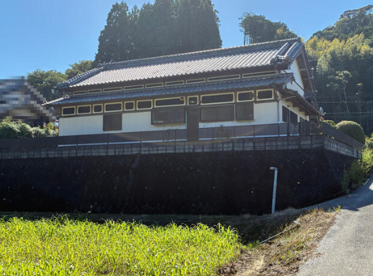 香南市香我美町上分の中古一戸建の外観|建物の背後に緑が広がる住環境。横に連なる窓が印象的な、趣のある和風住宅です。